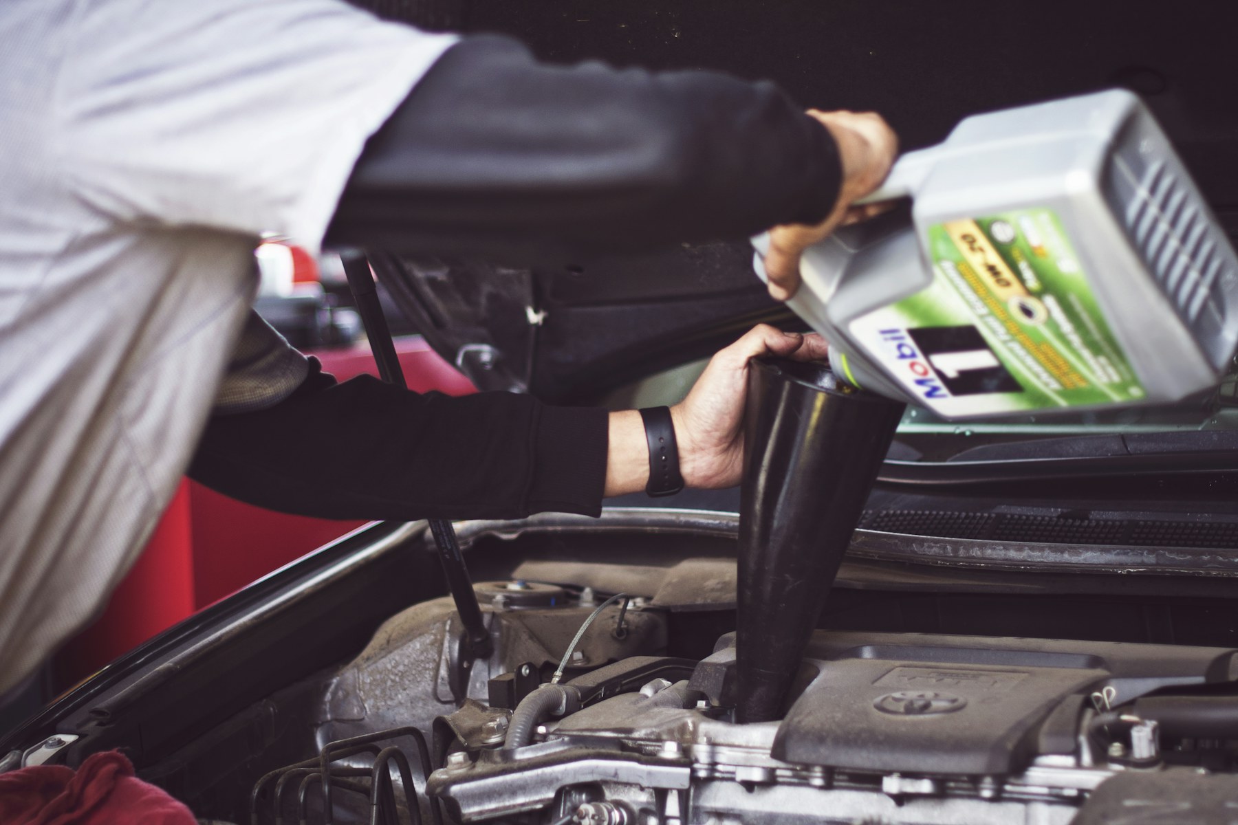 Mechanic inspecting the underside of a vehicle