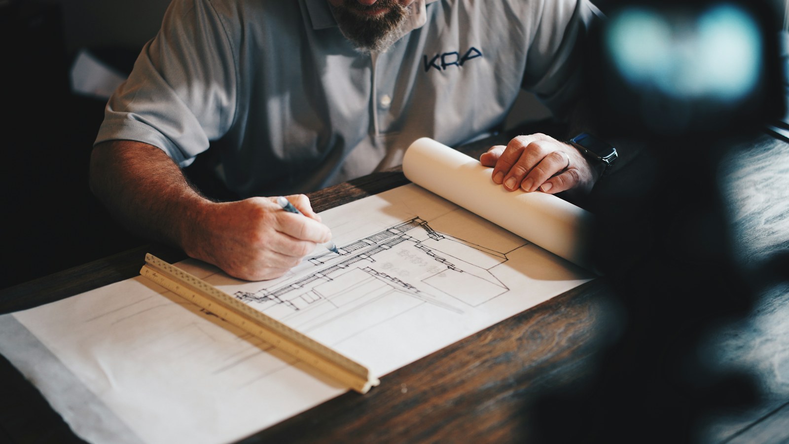 Professional drawing architectural plans at a table
